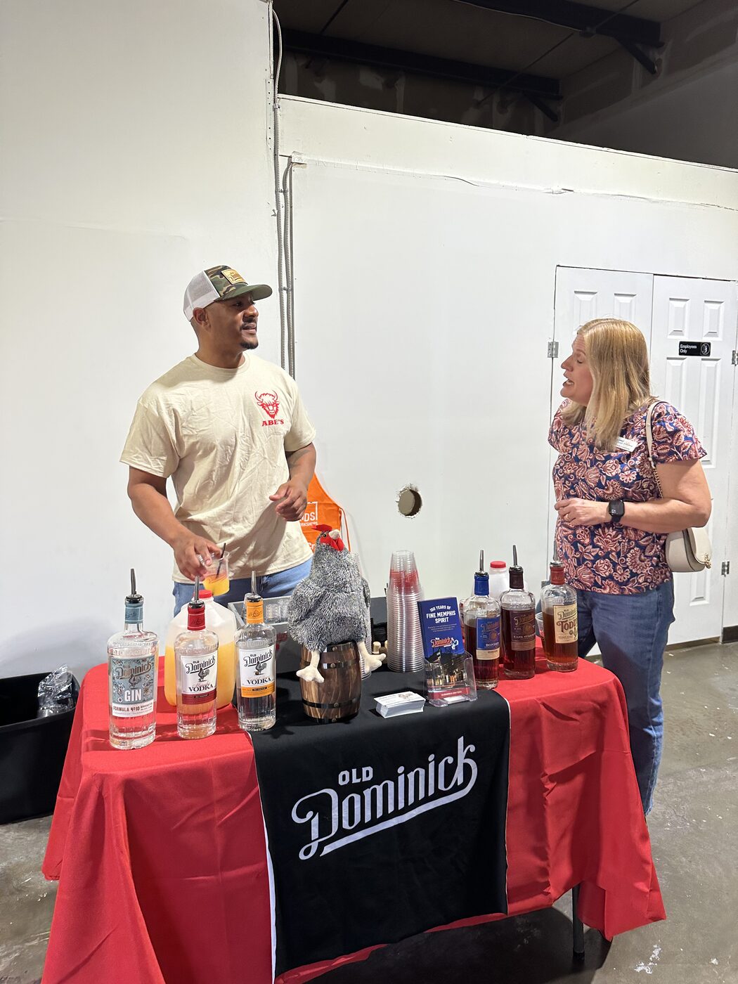 Two guests talking beside the Old Dominick drinks table at the B2B PM