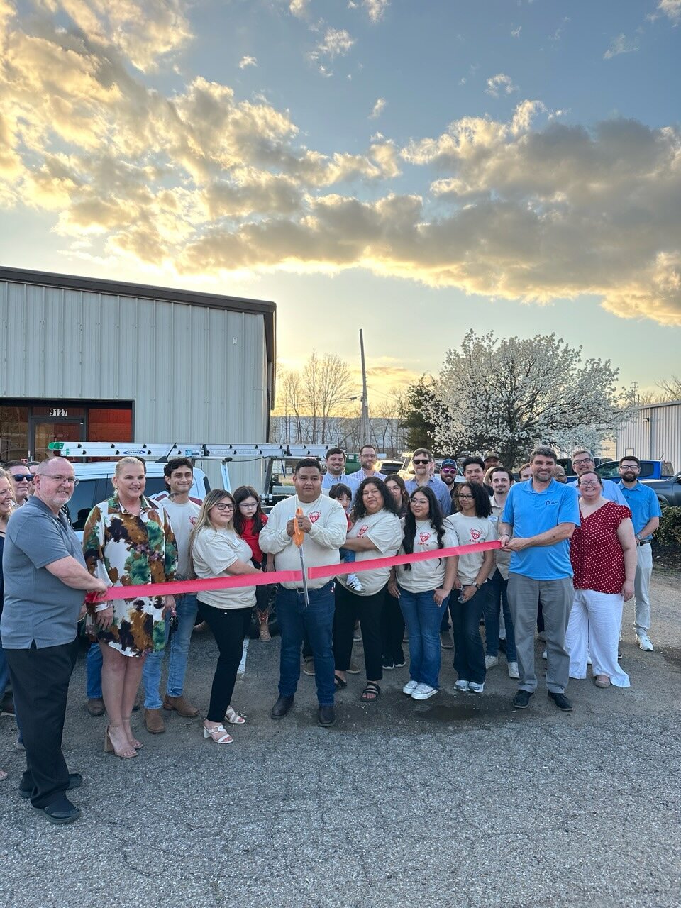 Group gathered with a ribbon outside Abe's Construction Co. during the B2B PM