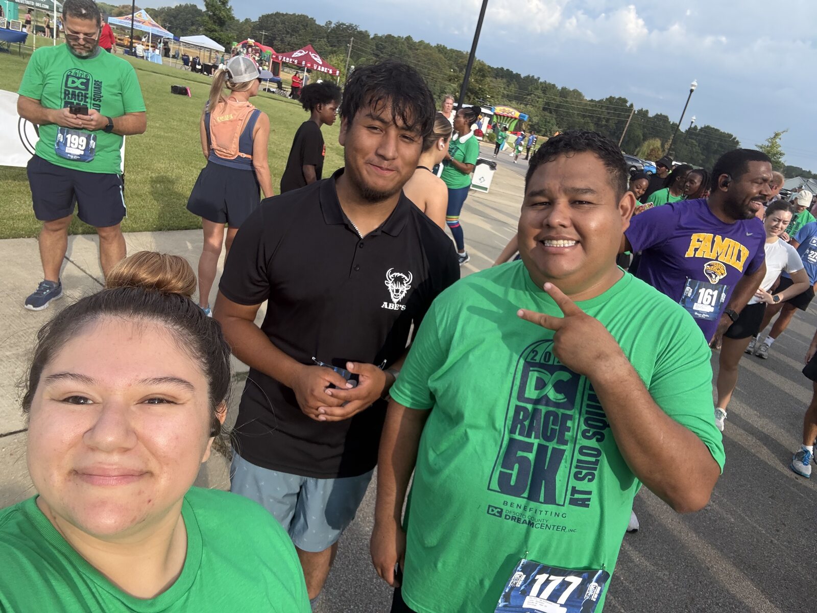 Three people posing among participants at the DeSoto County Dream Center 5K