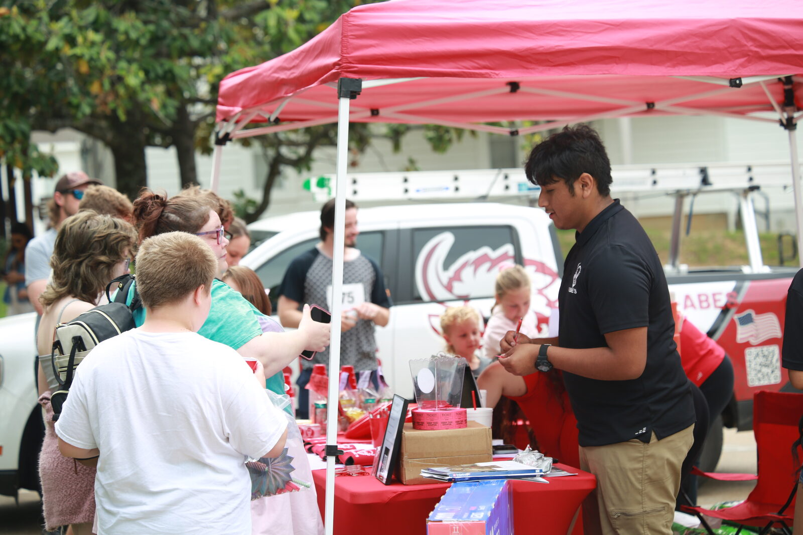 Visitors gathered at Abe's booth under a red canopy at Hernando A'Fair